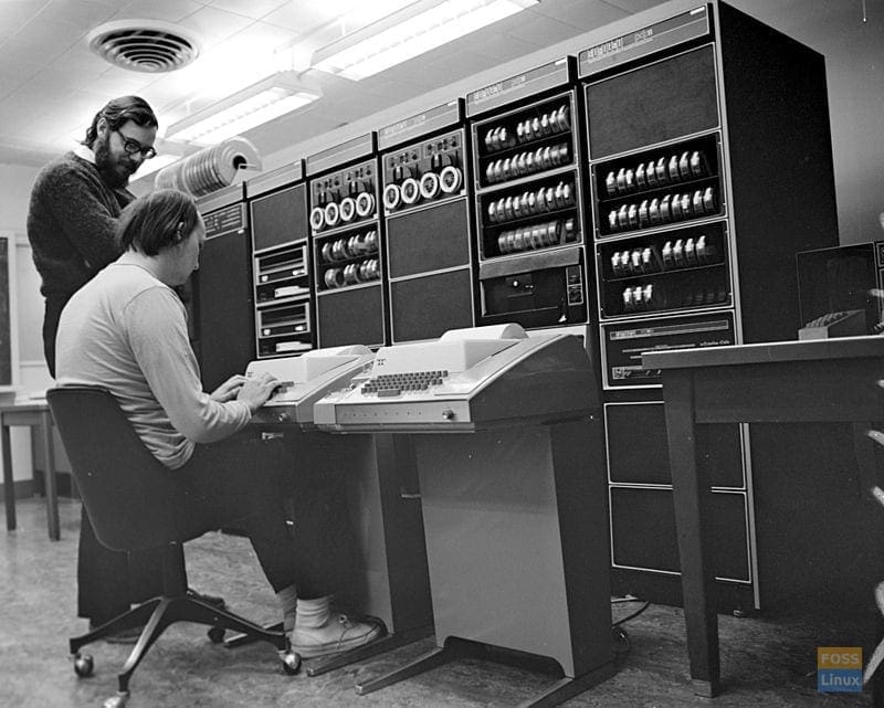 Ken Thompson and Dennis Ritchie (standing), part of the original Unix development team, at work on a PDP-11.